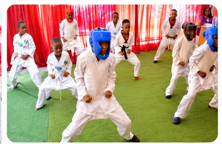 Pupils in white martial arts uniforms practising a stance during a taekwondo class